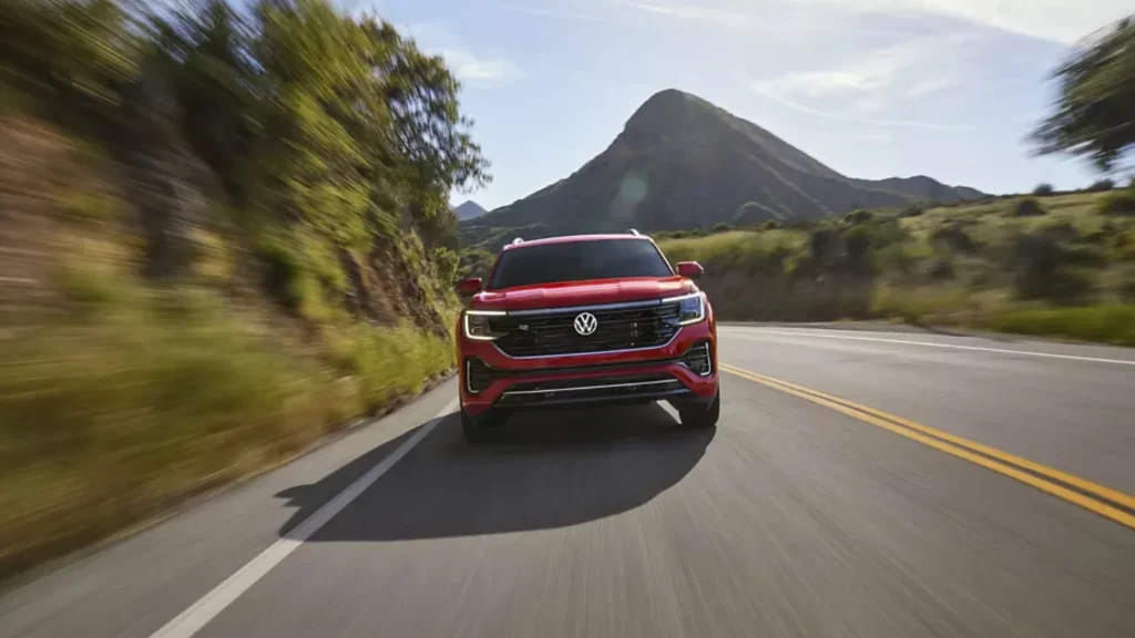2025 Volkswagen Atlas driving on a winding road near a mountain