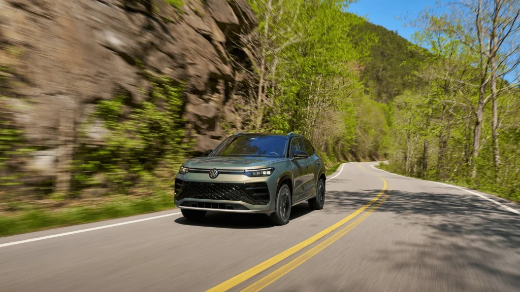 2026 Volkswagen Tiguan SEL R-Line Turbo SUV driving on a curving mountain road with bold front fascia design.