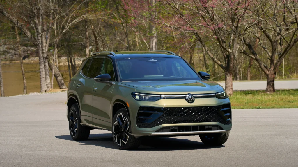 2026 Volkswagen Tiguan SEL R-Line Turbo in green parked on pavement, featuring sporty R-Line styling, black alloy wheels, and aggressive front grille.