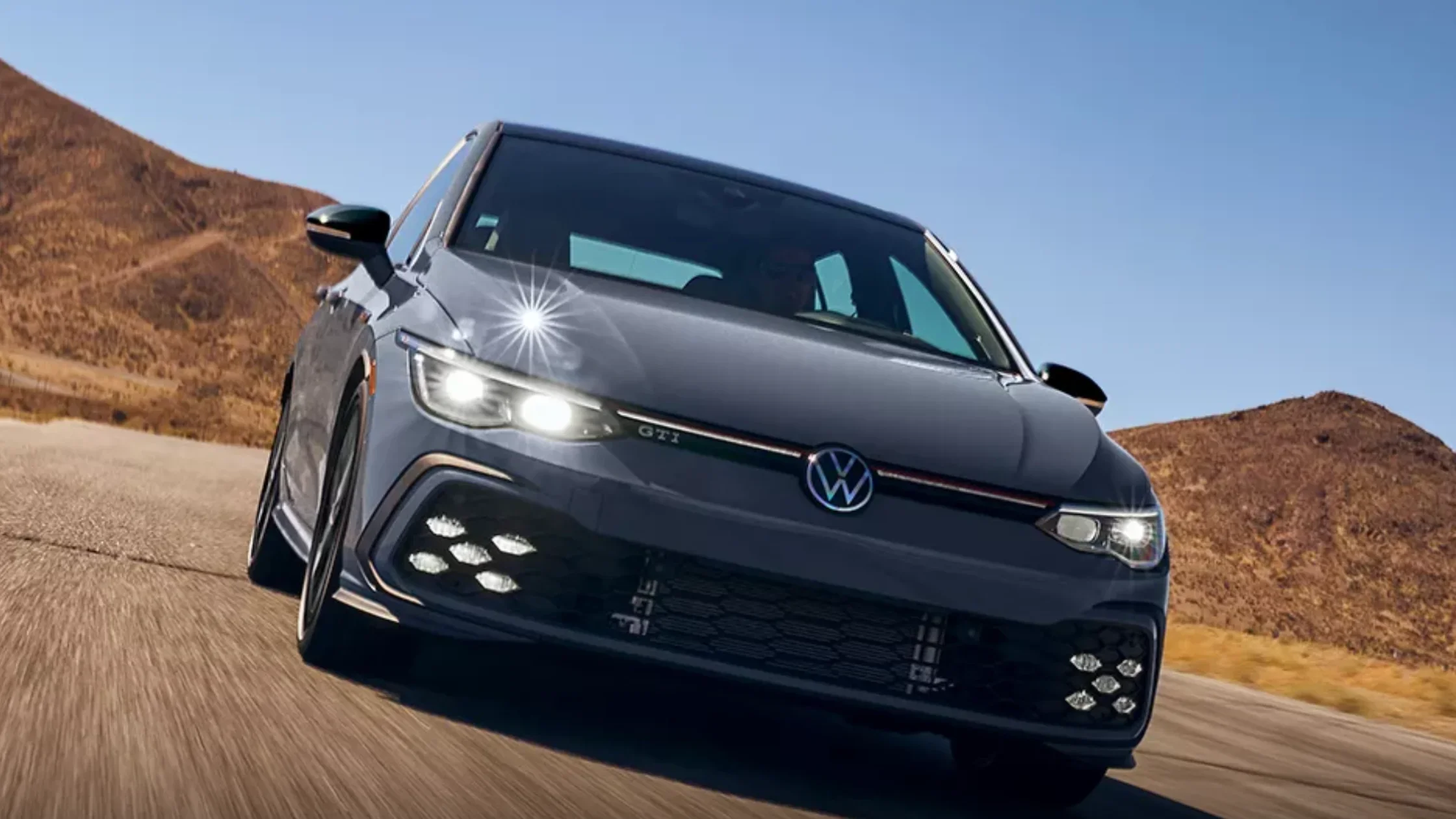 A 2020 Volkswagen Golf GTI drives along a scenic road near Charlotte, NC