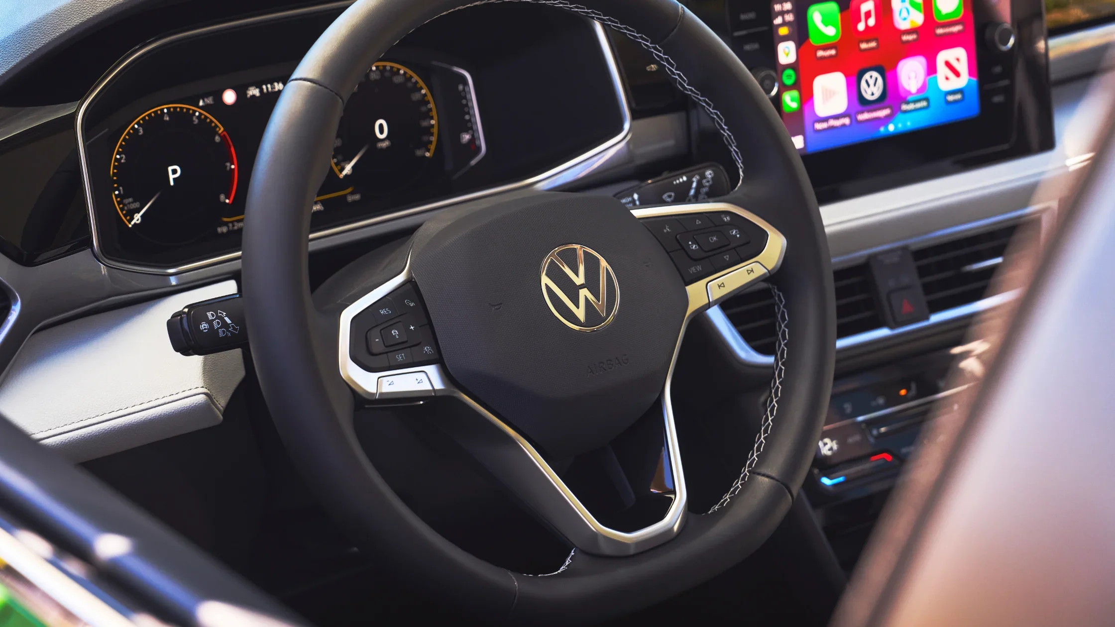 Close-up of the 2025 Volkswagen Taos steering wheel with digital gauges and infotainment screen.