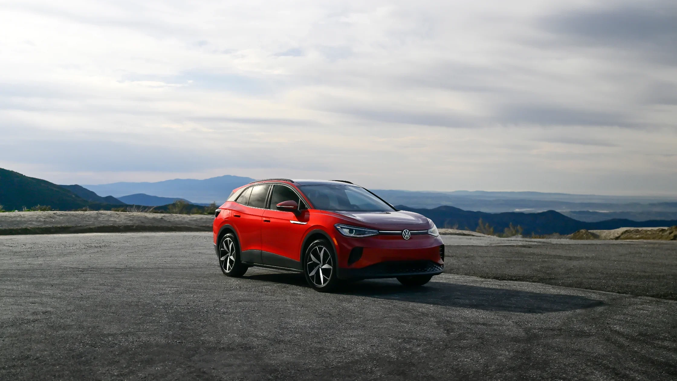 2025 Volkswagen ID.4 electric SUV parked on mountaintop overlook with panoramic view.