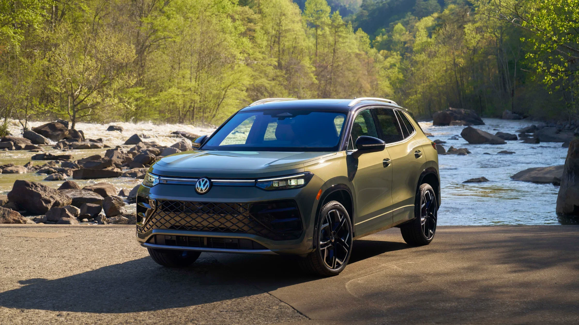 2026 Volkswagen Tiguan SEL R-Line Turbo parked by a river with forest background, front-side view