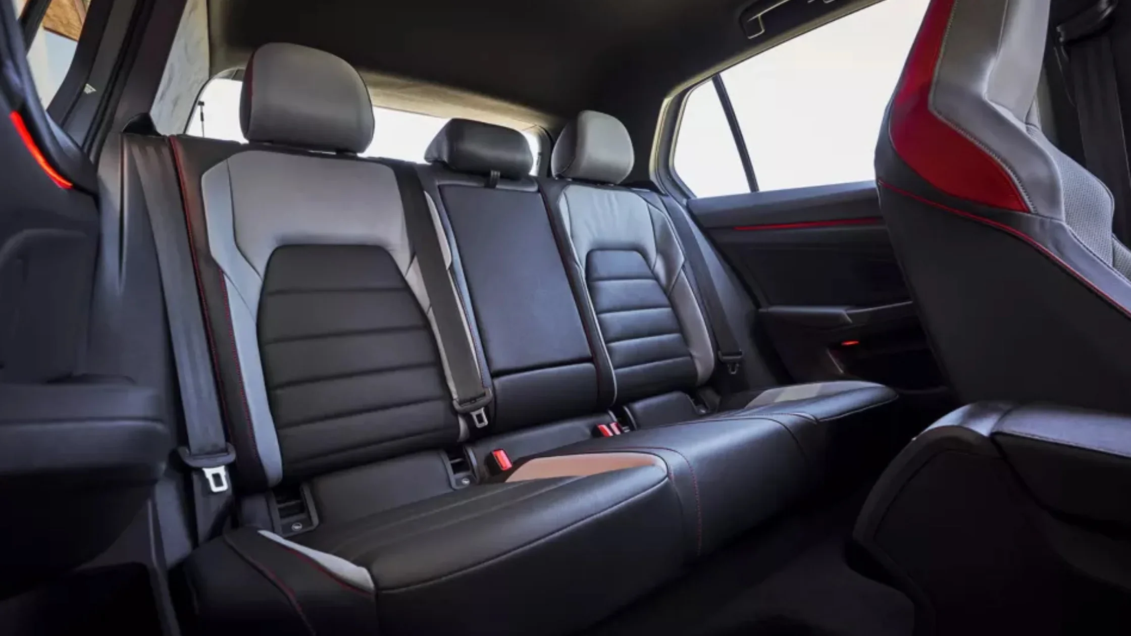 The rear seats of the 2025 Volkswagen Golf GTI with black and red sport upholstery.