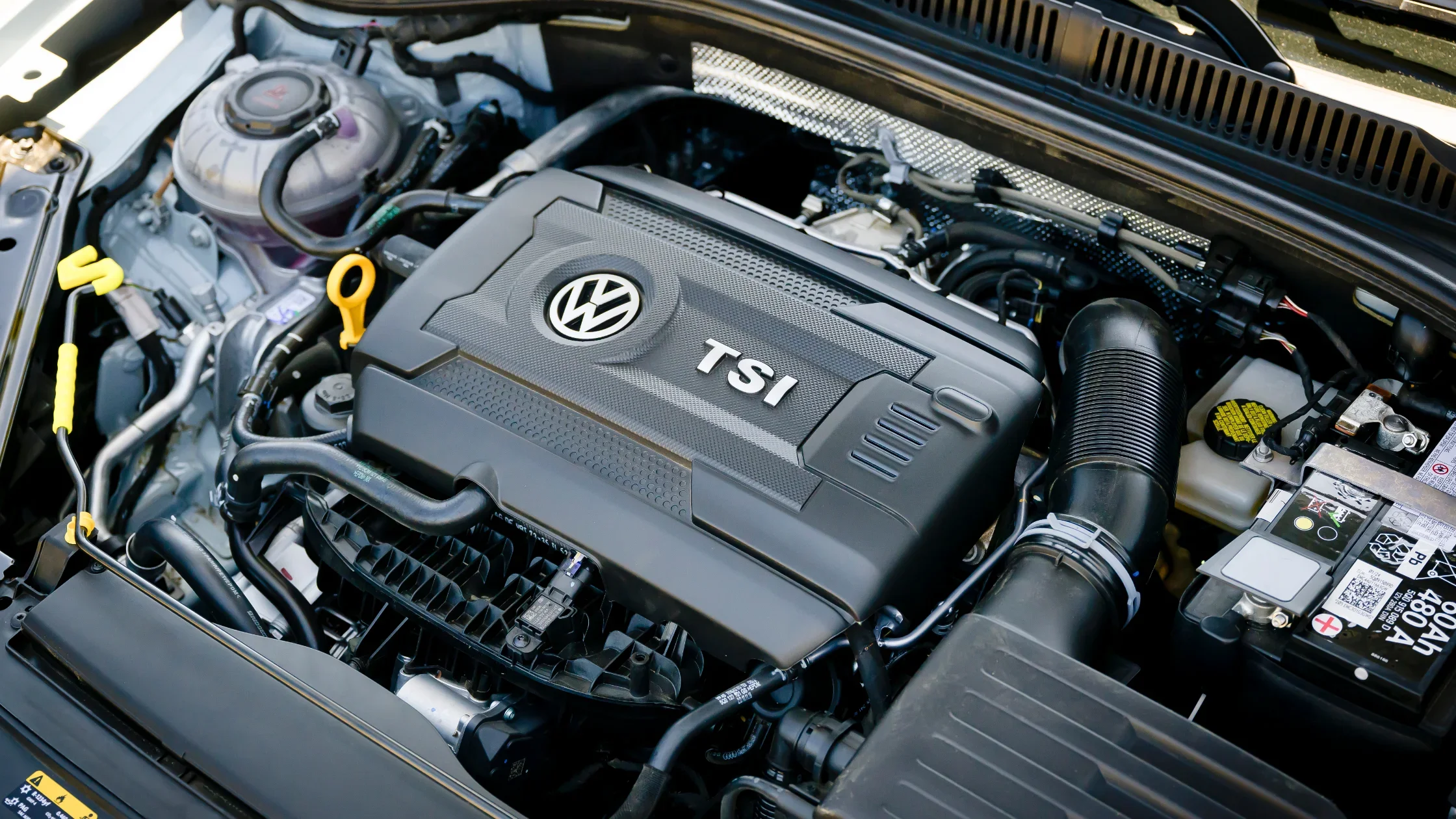 Close-up of a Volkswagen TSI engine under the hood of a car.