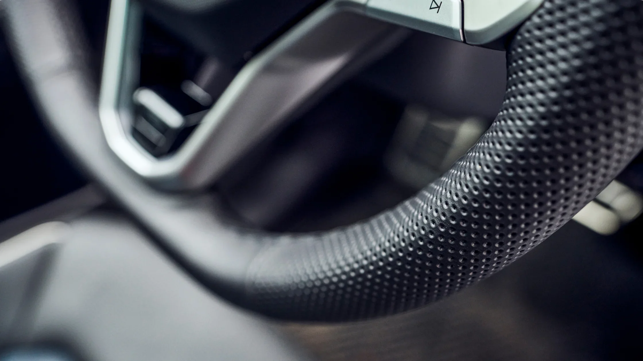 2025 Volkswagen Atlas Cross Sport steering wheel close-up with perforated leather grip.