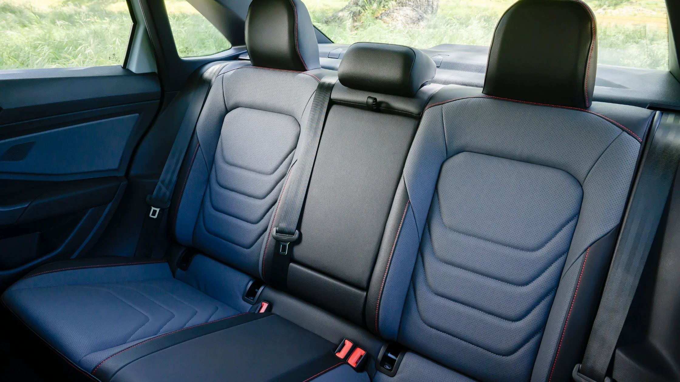 Rear seating of the 2026 Volkswagen Jetta GLI with leather upholstery and red contrast stitching.