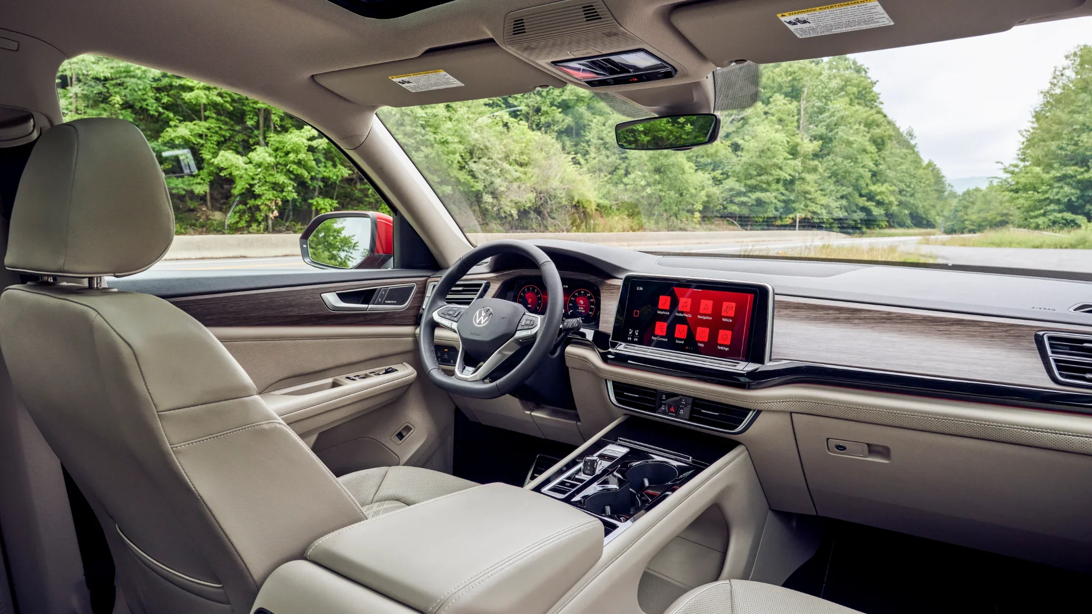 2026 Volkswagen Atlas interior front view with touchscreen display and beige seats.