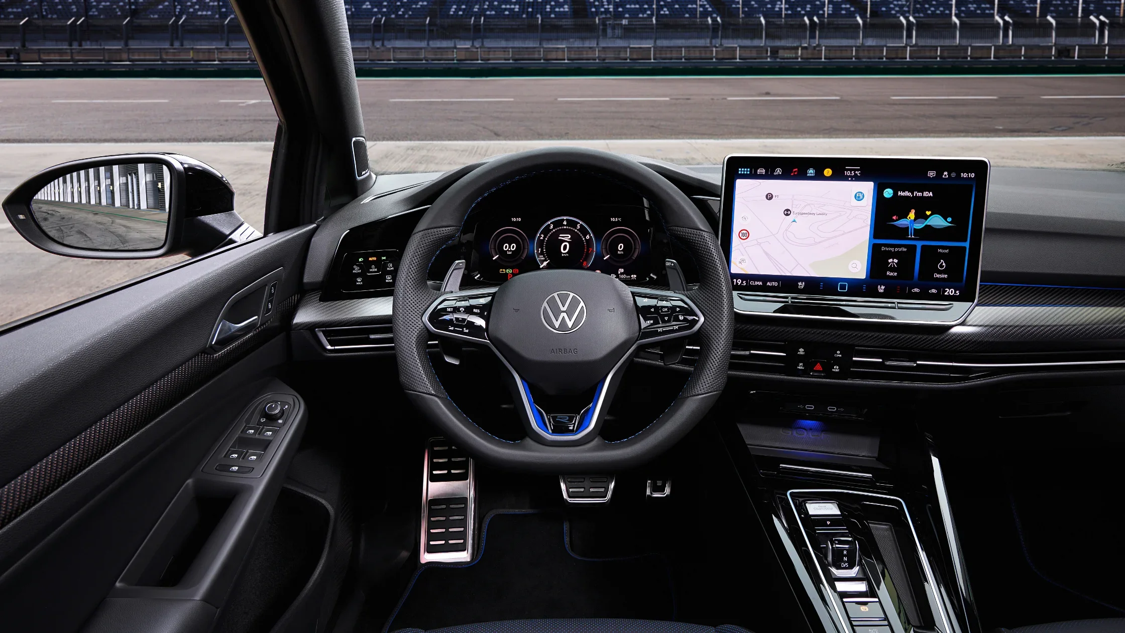 Interior view of the 2025 Volkswagen Golf R, featuring a digital cockpit, sporty steering wheel, and a large touchscreen infotainment system with navigation, highlighting its modern technology and driver-focused design.