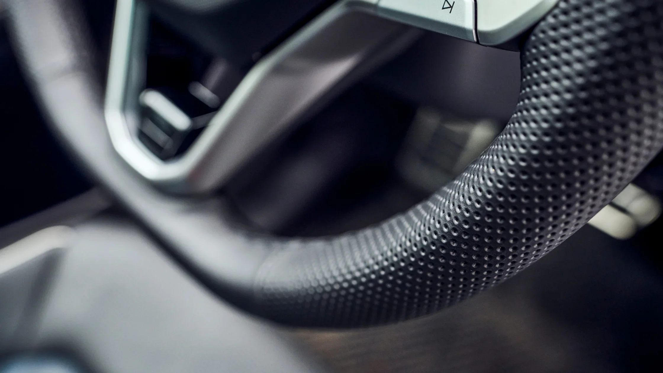 Close up of the 2026 Volkswagen Atlas Cross Sport steering wheel with perforated leather grip.