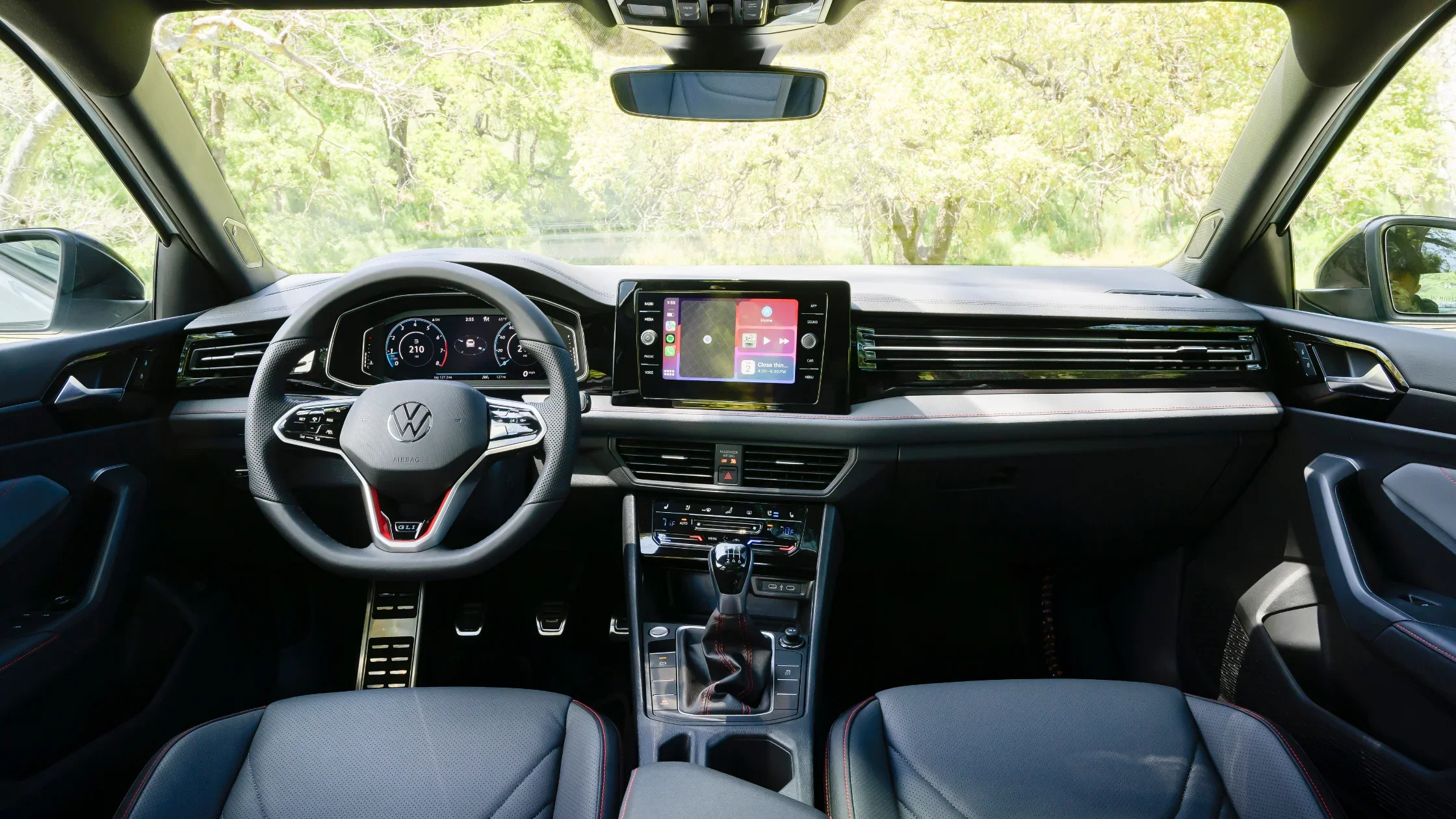 2026 Volkswagen Jetta GLI interior dashboard with sport steering wheel digital display and manual shifter.