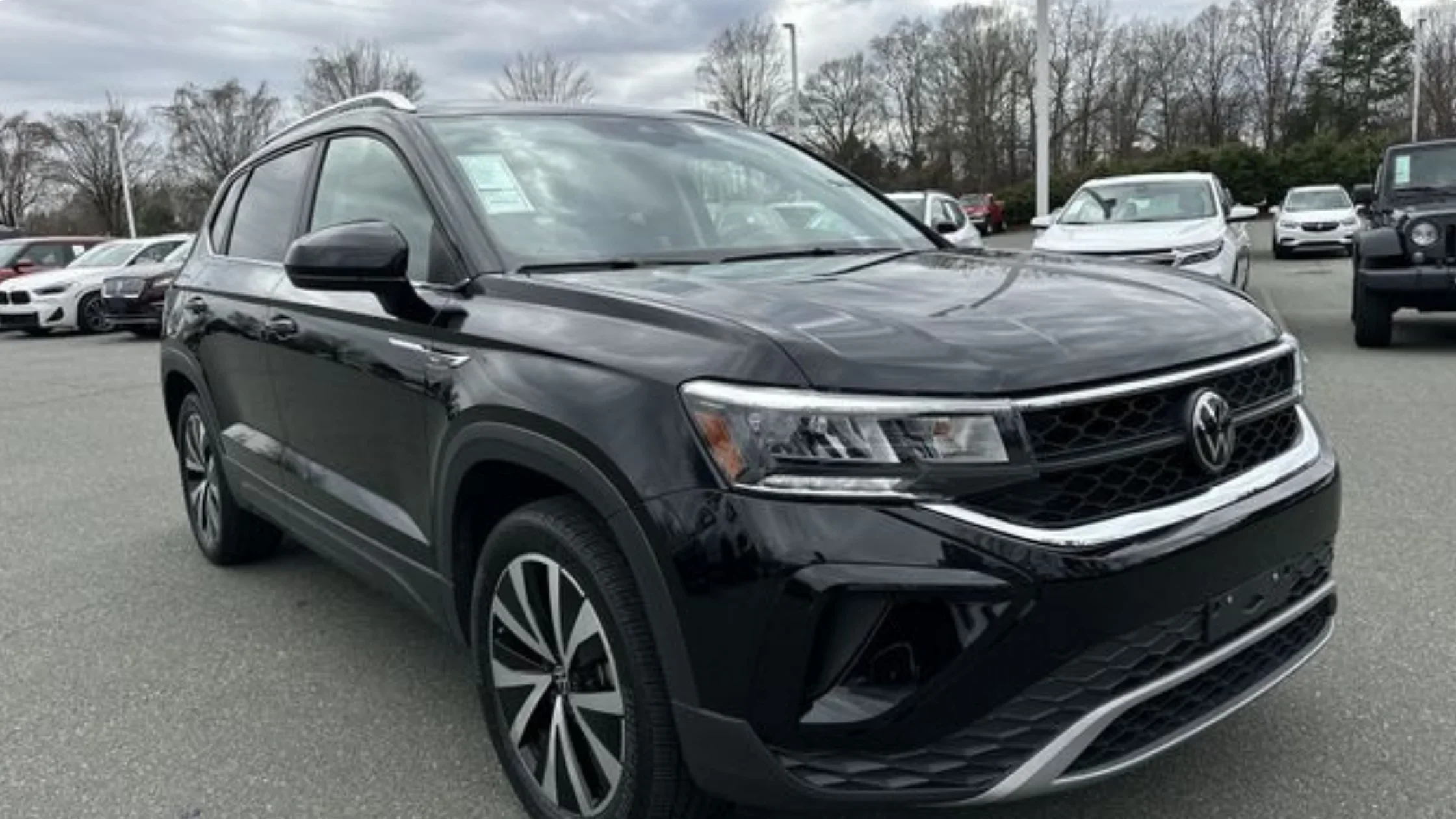 Certified Pre-Owned Volkswagen Taos compact SUV front three quarter exterior view parked at dealership lot.