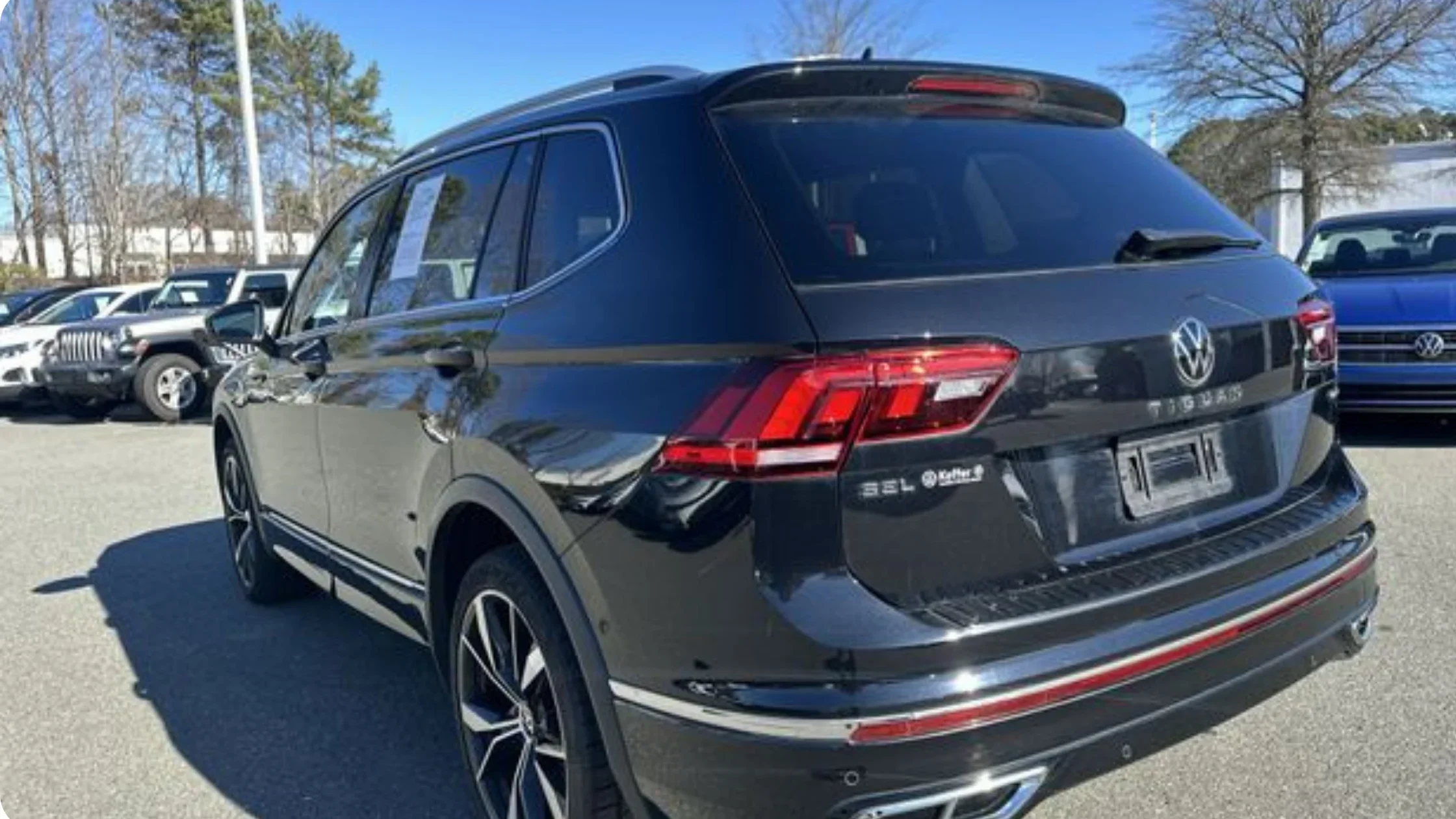 Certified Pre-Owned Volkswagen Tiguan rear three quarter exterior view highlighting SUV design and LED tail lights.