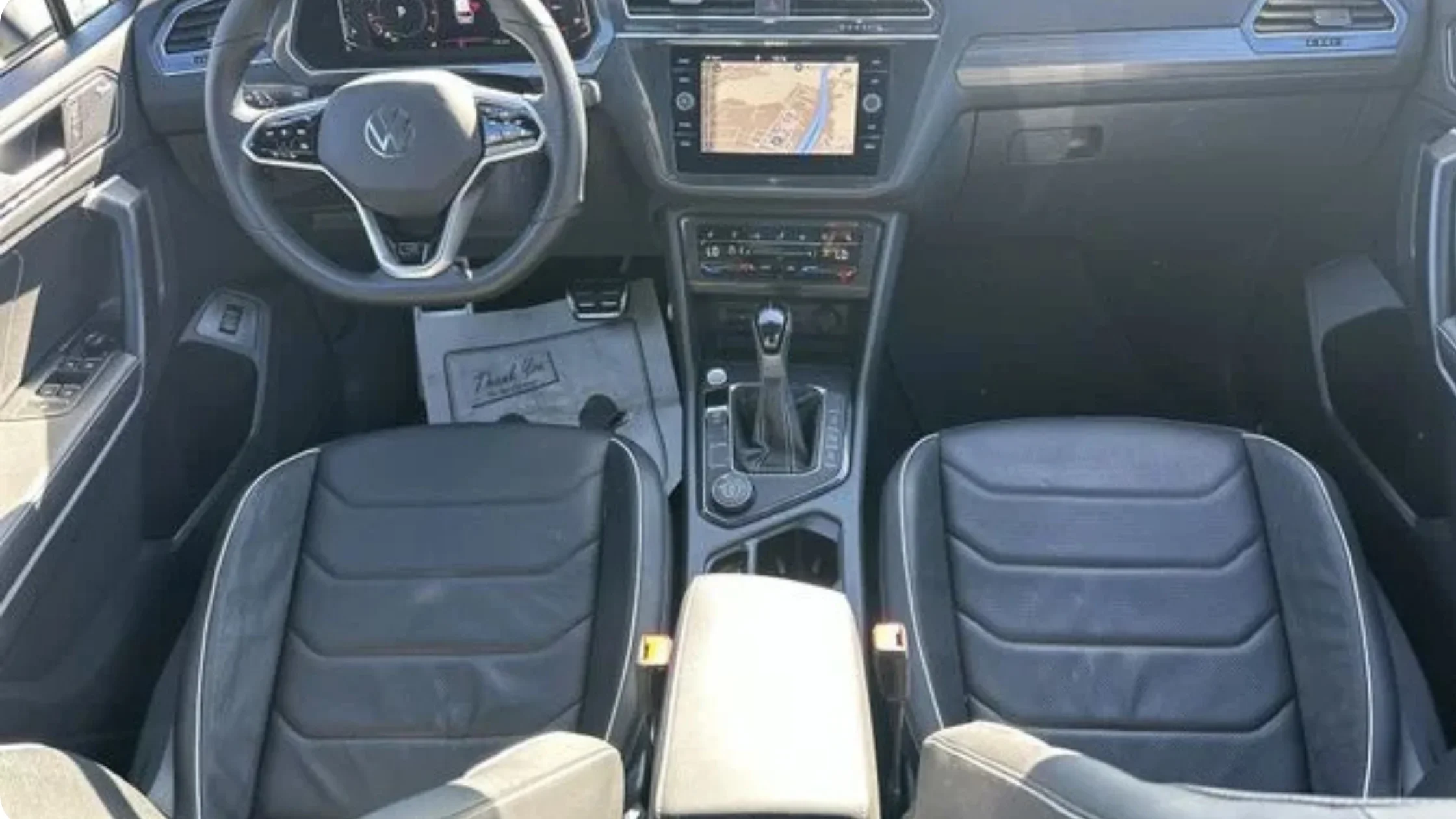 Certified Pre-Owned Volkswagen Tiguan interior cockpit with touchscreen navigation display and leather seating.